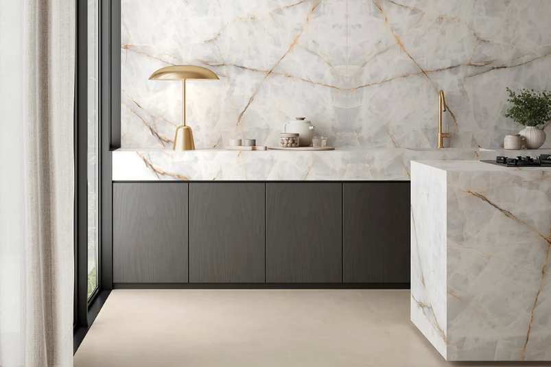 Cubierta y muro de cocina en piedra sinterizada ASCALE con apariencia marmoleada, ideal para espacios elegantes y luminosos.